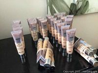 Overview photo showing all 34 tubes of Maybelline Dream Urban Cover foundation in various shades, arranged standing upright with some bundles.