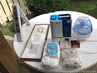 Photo showing all items: insta hanger, triple picture frame, Taotronics humidifier, Vicks vaporizer, two mop heads