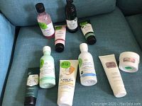 Photo of assorted The Body Shop skincare products laid out on a blue surface showing various bottles, tubes, and jars with visible green price stickers.