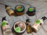 Photo of seven The Body Shop products including Shea hand lotion, dry oil, Argan oil whipped lotion, body butter, and exfoliating gel scrub with price stickers visible.