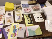 Photo of various blank Easter cards spread out on a table, including cards labeled Son and featuring colorful egg and floral designs alongside envelopes.