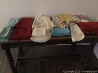 Photo showing assorted tablecloths and cloth napkins in various colors and sizes.