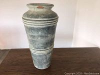 Full view of the tall ceramic planter with textured finish and horizontal ridges.