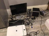 Photo showing entire lot including HP monitor, Gateway keyboard, Canon printer/scanner, Logitech speakers, subwoofer and mouse with cables scattered