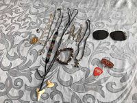 Full view of all items including jewelry, picks, pin and Ray-Ban lenses on patterned fabric
