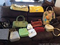 Full lot view showing approximately 15 assorted purses of various colors, materials, and styles, including leather and straw purses.