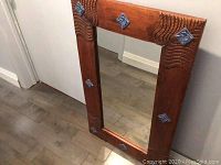 Wooden frame with ceramic tile inserts shown upright with floor as background