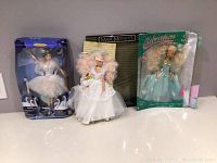 Three boxed dolls displayed: Barbie The Swan Queen in Swan Lake, Celebration Sandi doll, and Magic Moments Special Edition Sandi doll.