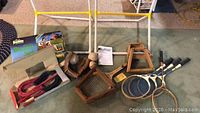 Wide view of the collection showing horseshoes, ring toss frame, wooden tennis rackets, croquet mallets, and part of bocce set.