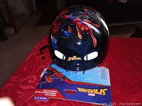 Front view of the new Spider-Man helmet with colorful graphics and tag.