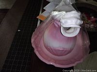 Overhead photo of the porcelain pitcher inside the large matching bowl, showing the horse mouth spout detail and pink gradient finish.