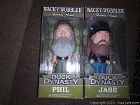 Front view of Phil and Jase Duck Dynasty Wacky Wobbler bobble head figures in original packaging.