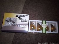 Box of Hoodies Collectible Auto Ornaments with metallic silver vintage car ornaments inside and box of four gold pear-shaped place card holders.