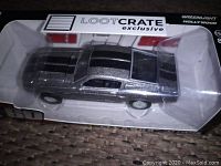 Close-up photo of the metallic silver diecast model Mustang in original Loot Crate exclusive packaging, showing top and side details of the car.