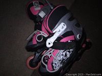 Pair of Kryptonics inline skates in pink, black, white, and grey, showing front and side views.