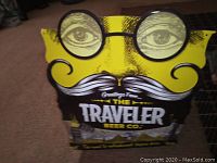 Front view of the tin sign showing the stylized face and printed text.