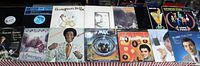 Photo showing 14 assorted record albums with artists including Simon & Garfunkel, Bill Cosby, Elvis Presley, Gladys Knight & The Pips, and more.