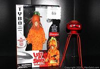 Front view of boxed Tybo The Carrot Man action figure and red wind-up space alien toy side by side