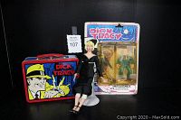 Photo showing the full set: Dick Tracy lunchbox, Breathless Mahoney figure seated on a white stand, and the Influence action figure in original packaging with card backing.