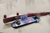 Angled view of both skateboards and Sk8er sticker