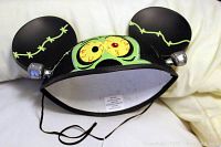 Front and top view of black Mickey Mouse ears hat with green Frankenstein stitching and cartoon eyes shown on front.