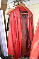 Red leather jackets and black leather jacket on hangers in closet