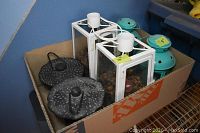 Box of lanterns showing two cast iron ones and four white metal frame lanterns with glass panels