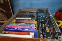 Photo showing a box of assorted DVDs from various movies and TV shows including Harry Potter and others, viewed from above