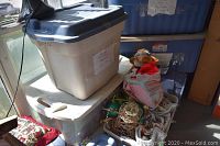 Three large plastic storage totes stacked, containing Christmas decorations.