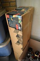 Photo of the cardboard box packaging for the Noma fibre optic Christmas trees, showing stacked boxes with Noma branding and product information.