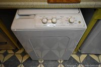 Front view of Whirlpool portable washer showing the closed lid and control panel above.