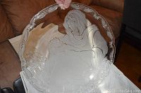 Front view of the Mikasa glass platter showing Mary holding baby Jesus etched in the center with grapevine decorative edges.