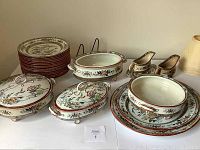 Full overview of stack of plates, covered dishes, gravy boats and ladle on display table