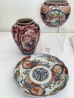 Photo of all three items in the set: two vases and one plate, showing overall design and scale.