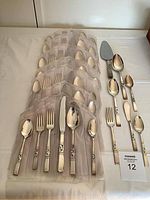 Full array of 55 silverplate flatware pieces arranged, showing place settings and serving utensils.