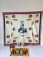 Overall display of all items including 1937 King Edward VIII tablecloth, two coronation mugs, and two fabric flags.