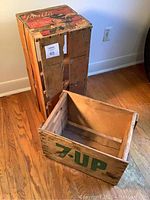 Image showing full view of aged wooden Rosita fruit crate with painted top featuring a woman and text, next to open 7Up wooden crate.
