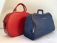 Two vintage Air Canada flight bags side by side, red vinyl and blue material