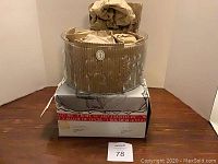 Photo of original boxes and packaging for the Italglass Flora salad bowl set, showing unopened bowls wrapped in brown paper inside corrugated cardboard container placed on top of the retail box.