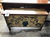 Front view of pine trunk with stenciled floral design and '1820' date, showing overall appearance