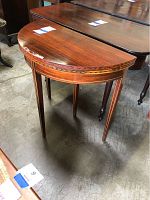 Half moon flip top side table with wood inlay on legs and edges, showing overall good condition.