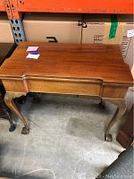 Closed flip top table showing claw feet and wood grain finish