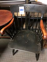 Front view of wooden Princeton arm chair showing black finish, natural wood armrests, Princeton emblem on top rail.