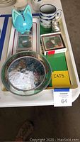Top view of the cat-themed items arranged in nested trays including piggy bank, mug, figurine, and boxed coasters