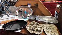 Full view of kitchen items showing platters, pans, molds, graters, rolling pin, and wine rack.