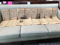 Set of folded newspapers laid out on a couch showing multiple headlines including Titanic sinking and Roosevelt's death