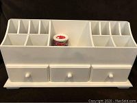 White wooden jewelry and makeup organizer with three drawers and divided top compartments