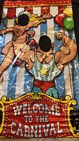 Carnival-themed cutout banner with strongman and strong lady designs and face cutouts