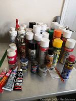 Photo of assorted aerosol cans and tubes including Loctite, Share Corp, Gunk, WD-40, Vaseline, and others