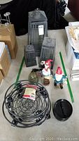 The full lot showing glass and metal lanterns, garden gnomes, ceramic turtle lamp, garden planter dollies, and various ashtrays.